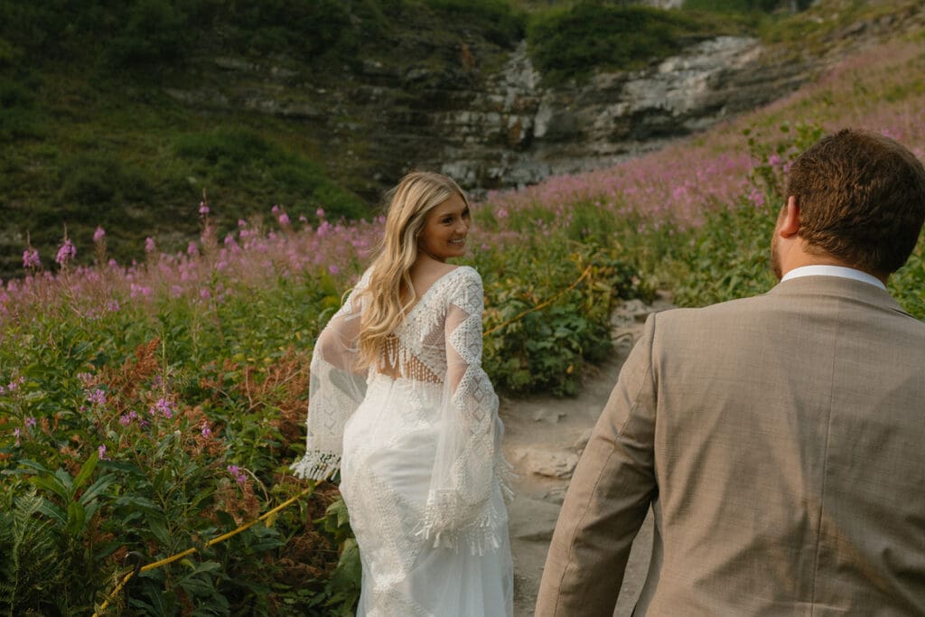 bride looking back and smiling while hiking