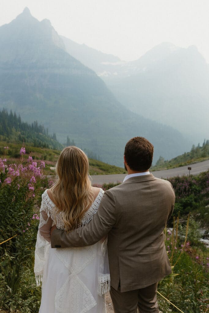 Bride and groom from behind looking at the mountains