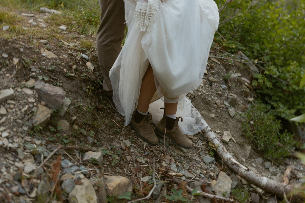 Bride and groom's hiking boots while walking in rocks.